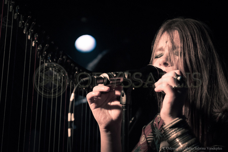 gros plan sur la chanteuse du groupe Djinn avec une harpe en arrière-plan
