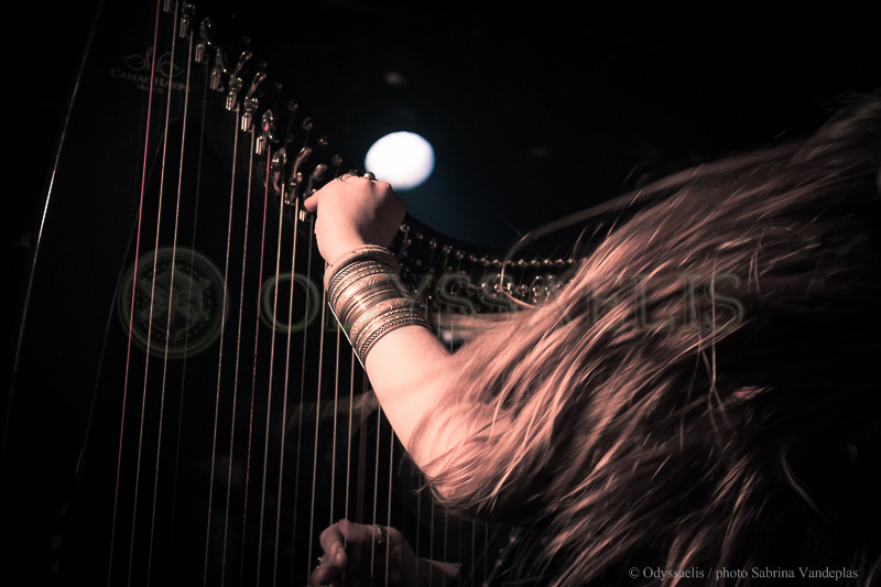 gros plan de la main gauche sur la harpe et des cheveux en mouvement de la chanteuse du groupe Djinn